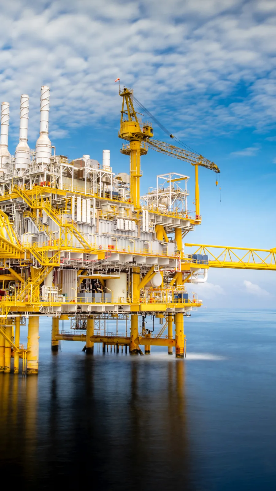 Plataforma offshore de petróleo e gás em mar aberto, com guindaste e módulos de processo